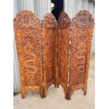 Well carved Oriental three fold screen decorated with dragons etc 6' high