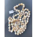 A fancy cultured pearl necklace with a mixture of pink and white over four foot