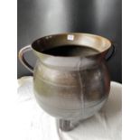 A antique bronze cauldron with two loop handles on three legs 13 and a half high inches high