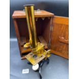 A brass microscope in mahogany case