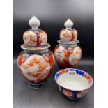A pair of Imari jars and covers with flower panels and a small bowl