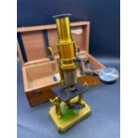 A brass microscope in a mahogany case, 10.5" high