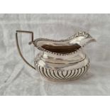 A Chester silver cream jug, half fluted with gadroon rim, 5.5" wide, 1912 by CR,RH, 164g