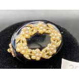 A EARLY VICTORIAN REAL PEARL AND ONYX WREATH SHAPED BROOCH WITH ORIGINAL PLAITED HAIR TO REVERSE