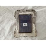 A shaped oblong photo frame decorated with scrolls, 7.5" high, Birmingham 1908 by WN