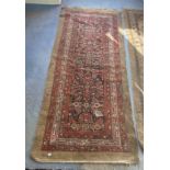 An Antique red ground oriental hall carpet 10ft x 4ft 4"