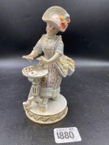 A Meissen figure of a lady seated at table 6 inches high