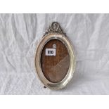 An Edwardian oval photo frame with ribbon surmount, 8” high Birmingham 1908