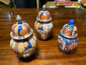 A pair of Imari vases and covers plus another 8 inches