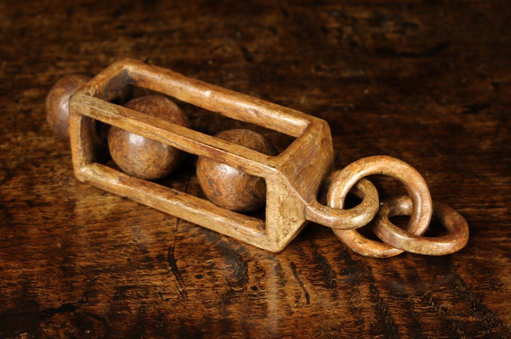 A Welsh Treen 'Lantern Form' Love Token with two balls encases in a square section cage hanging