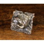 A 17th Century Ornamental Block Appliqué carved in the form of a lion's head, 3¾" (9.5 cm) high,
