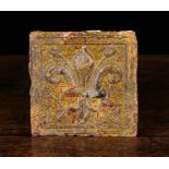 An 18th Century Glazed Earthenware Tile moulded in relief with a fleur-de-lys flanked by initials N
