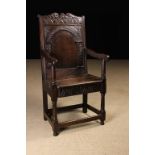 A 17th Century Oak Wainscot Chair. The broad arcaded panel back in a guilloche carved arch with