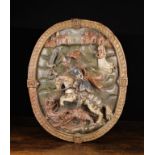A 16th Century Relief Carved & Polychromed Oval Plaque depicting Saint George on horseback wielding