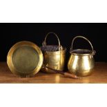 Two Antique Brass Culinary Pots with swing handles and a brass frying pan with a rolled rim, mounted