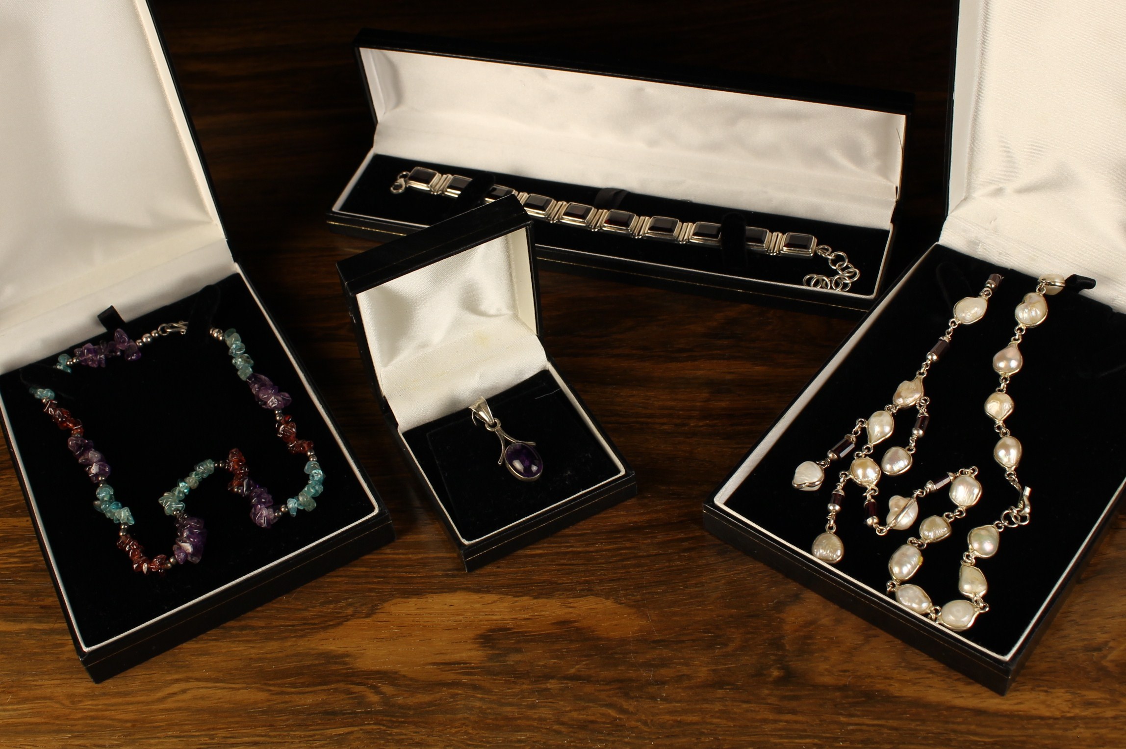 Two Necklaces, a Bracelet and a Pendant housed in 'Expressions' presentation cases.
