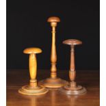 Three 19th Century Treen Wig Stands: The tallest with a domed mushroom top raised on a baluster