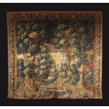 An Early 18th Century Verdure Tapestry depicting a densely wooded parkland with flowering shrubs to