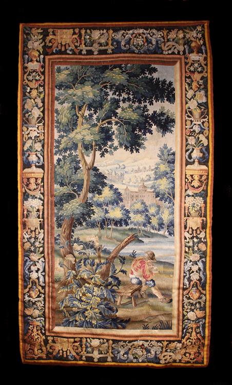 An Early 18th Century Flemish Tapestry depicting a peasant man sat on a rustic bench beneath a tall