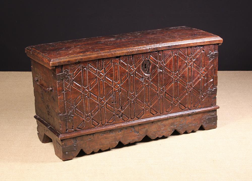 A 16th Century Spanish Carved Chestnut Coffer having a thick single piece lid with stepped reeding