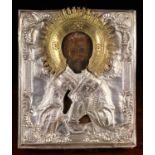 A 19th Century Russian Icon overlaid with an embossed silver & gilt coloured two part sheet metal
