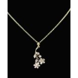 An Edwardian Diamond and Gold Flower Pendant on a silver chain.