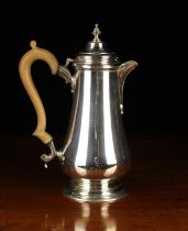 A Silver Lidded Baluster Hot-Water Jug on a raised foot with scroll crested wooden handle,