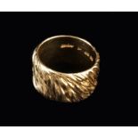 An 18 Carat Yellow Gold Ring by Kutchinsky; the broad band textured with wrythen strands,