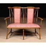 An Early 20th Century Twin Chair-back Settee having two padded rectangular back panels and a padded