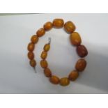 A string of 18 amber type butterscotch beads - Length 49cm - largest bead approx 34mm x 22mm - total