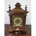 An 8 day walnut bracket clock with quarter chime on two gongs, brass and silvered dial - running