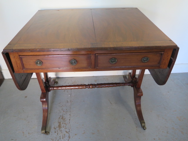 A late 19th century mahogany drop leaf sofa stretcher table with two active and two dummy drawers on