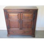 An oak cupboard with two panel doors and a base drawer - Height 95cm x 92cm x 27cm