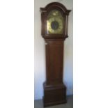 An oak three train chiming longcase clock with a brass arched 12inch dial signed John Simpson,