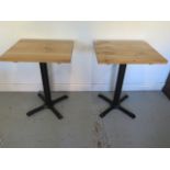 A pair of new wooden top café tables on steel bases - Height 75cm x 50cm x 60cm