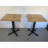 A pair of new wooden top café tables on steel bases - Height 75cm x 50cm x 60cm