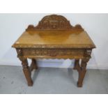 A Green Man carved oak hall/side table with a drawer - with good light colour and polished