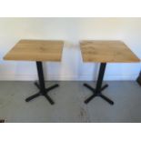 A pair of new wooden top café tables on steel bases - Height 75cm x 50cm x 60cm