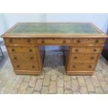 A Victorian light oak nine drawer twin pedestal desk with a leather inset top small moulding