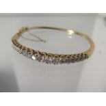 A 9ct yellow gold 18 stone diamond hinged bracelet 6cm x 5.5cm external - approx weight 15.4 grams -