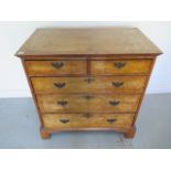 A Georgian and later walnut five drawer chest with quarter veneer top standing on bracket feet -