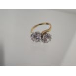 A 9ct yellow gold crossover CZ ring each approx 8mm diameter - ring size O - approx weight 4.7grams