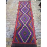 A hand knotted woollen rug - 275cm x 77cm