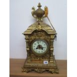 A heavy brass ormolu striking mantle clock, 48cm tall, with a key and pendulum, appears overwound
