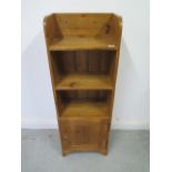 A waxed pine bookcase with cupboard - good colour and polished finish - 109cm x 38cm x 23cm