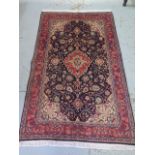 A hand knotted woolen Kashan rug - 2.10m x 1.30m - in good condition