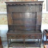 An oak dresser with a racked top above the potboard base - Width 180cm x Depth 43cm x Height 230cm