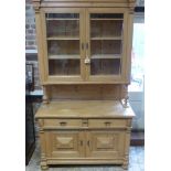 A good versatile Continental stripped pine dresser with a two door glazed top over a stand and a bas