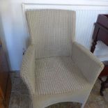 A Neptune Lloyd Loom style armchair in off white