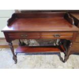 A Victorian mahogany washstand/desk with under tier - galleried top and two frieze drawers - in